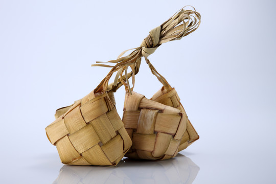 白色背景的饺子。Ketupat是一种天然米壳，由年轻的椰子叶制成，用于在穆巴拉克开斋节期间煮饭