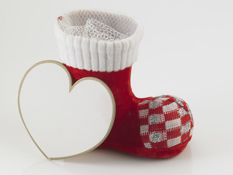 圣诞老人的靴子或鞋子，白色背景上有心形卡片