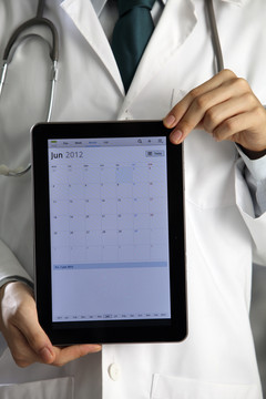 医生手持并展示数字平板电脑。