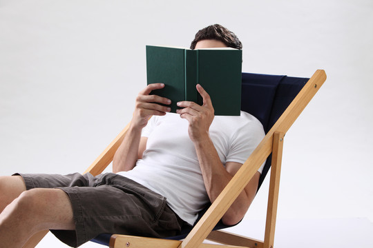 躺在躺椅上看书的男人-脸上蒙着