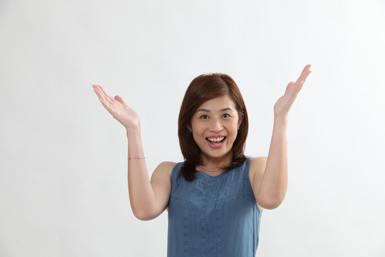 一位中国妇女举着胳膊微笑着看着摄像机