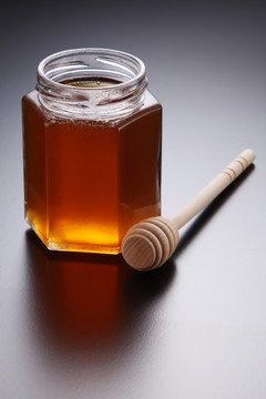 蜂蜜放在装有木勺的玻璃容器里