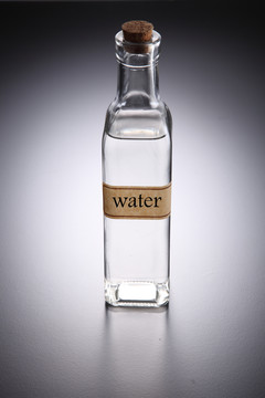 灰色背景上的一瓶透明液体