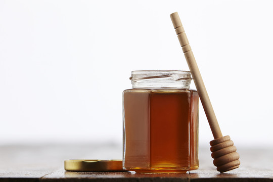 木桌上放着一罐蜂蜜