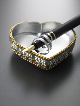 戒指、钢笔和心形珠宝盒