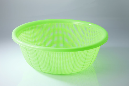 白色背景上的绿色塑料篮