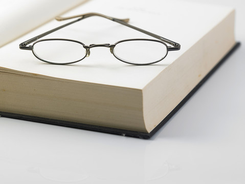 一本打开的精装书和一副阅读眼镜