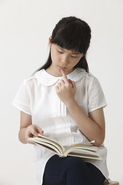 中国女孩拿着一本书在看书