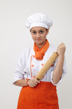 一个穿着厨师制服拿着擀面杖的印度女人的肖像