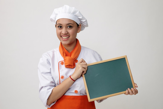 一个穿着厨师制服拿着黑板的印度女人的肖像