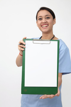 女护士医生微笑着拿着听诊器，出示空白的剪贴板。