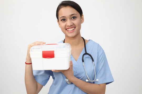女护士或医生携带便携式急救箱隔离在白色地板上
