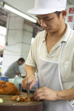 小贩摊上准备鸡饭的男子