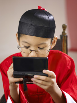 小男孩在过年时玩手持式电子游戏