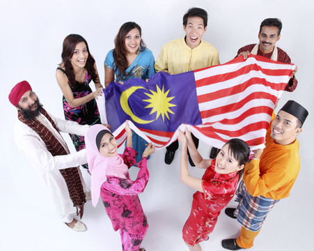 一群多种族的人站成一圈，举着马来西亚国旗