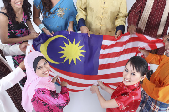 多种族人士手持马来西亚国旗站成一圈的特写镜头