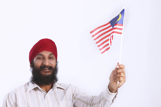 中年男子头戴头巾举马来西亚国旗