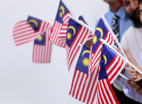 一群手持马来西亚国旗的男女合影