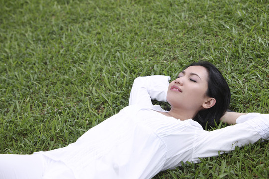 年轻女子躺在草地上的俯视图