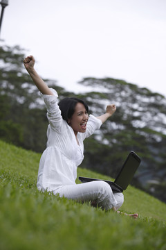 兴奋的年轻女子使用笔记本电脑