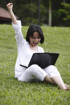 一个快乐的年轻女人和她的笔记本电脑