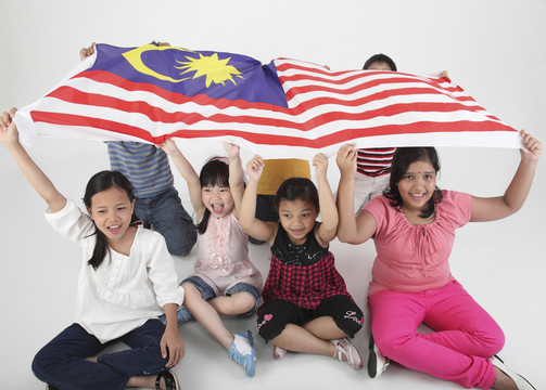 手持马来西亚国旗摆姿势的多种族儿童