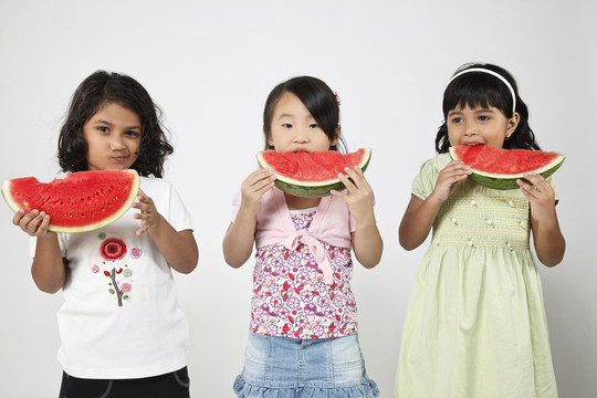 三个孩子在吃西瓜