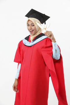 穿着毕业礼服拿着毕业证书的年轻女子