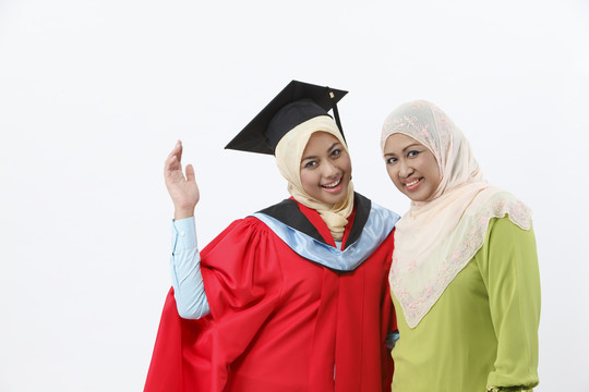 年轻的毕业生和她的母亲在镜头前微笑