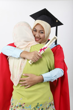 年轻的毕业生拥抱着她的母亲