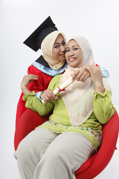 年轻的毕业生拥抱着她的母亲
