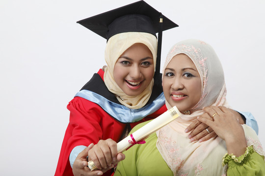 年轻的毕业生和母亲一起拿着毕业证书