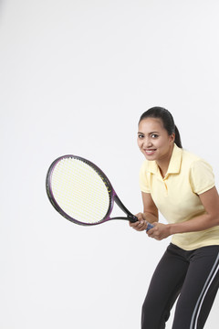 手持网球拍的马来妇女。
