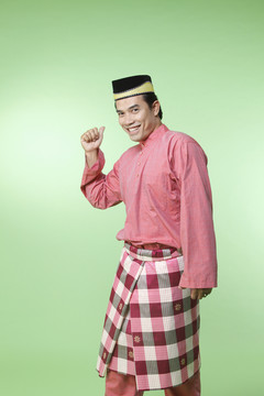 绿色背景上穿着传统服装的马来人