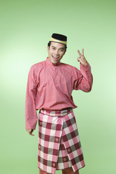 马来男子带着传统服装用手势二