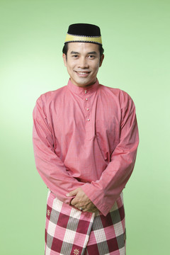 身着传统服装的马来男子对着镜头微笑