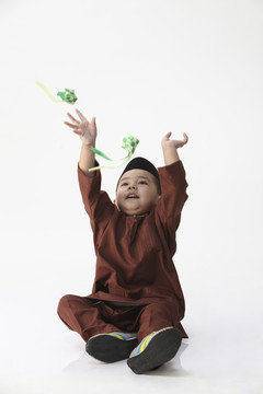 马来男孩在白色背景上玩装饰的凯图帕特