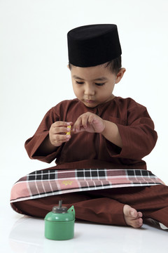 马来男孩在玩五颜六色的佩利塔
