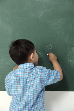 男孩在黑板上写字或画画