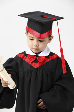 男孩穿着毕业礼服和毕业证书的股票形象