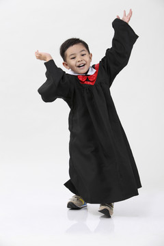 穿着毕业礼服跳舞的男孩的股票图像