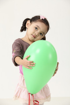 手持绿色气球的马来小女孩
