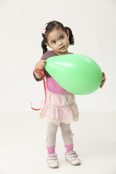 手持绿色气球的马来小女孩
