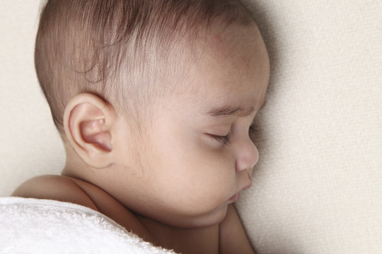 新生儿被白色毯子覆盖的特写镜头