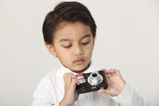 年轻的马来男孩拿着相机