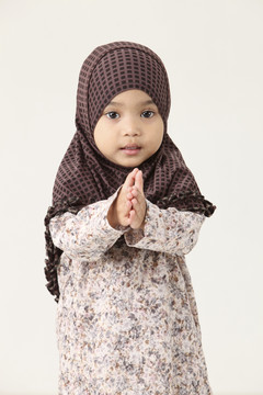 年轻的马来西亚穆斯林女孩举手致意