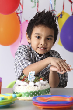 男孩用在生日蛋糕前，开心