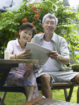夫妻俩在花园里看报纸