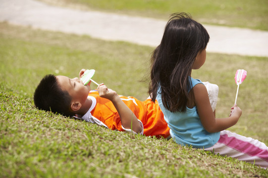 男孩和女孩在公园吃棒棒糖