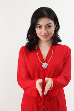 身着红色凯巴亚服装的马来妇女致意